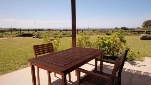 a wooden table and two chairs on a patio at Roccabianca in Sorso