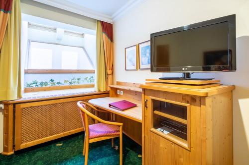 a room with a desk with a tv and a chair at Hotel Zum Schwarzen Bären in Emmersdorf an der Donau