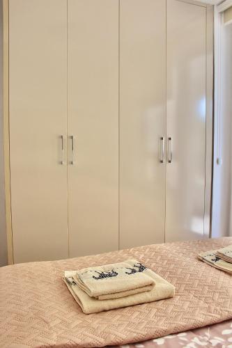 a bed with white cabinets and a towel on it at Ramonda Residences - New Belgrade in Belgrade