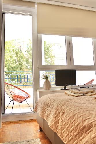 a bedroom with a bed and a tv and windows at Ramonda Residences - New Belgrade in Belgrade