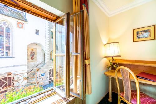 a room with a window and a desk and a lamp at Hotel Zum Schwarzen Bären in Emmersdorf an der Donau
