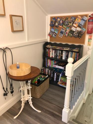 una habitación con una mesa y un estante de libros en Flat 1, 22 the square centre of Dalston village en Carlisle