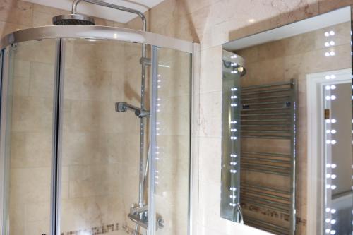 a shower in a bathroom with a mirror at The Tollemache Arms in Buckminster