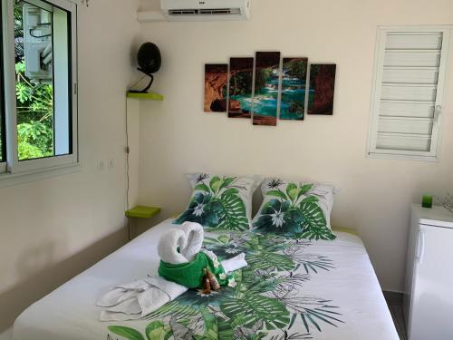 a bed with towels and a stuffed animal on it at Ô TI JACKO in Le Gosier