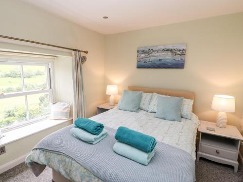 a bedroom with a bed with blue pillows on it at Margaret's Cottage in Feetham