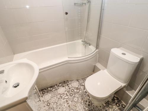 La salle de bains blanche est pourvue de toilettes et d'un lavabo. dans l'établissement Margaret's Cottage, à Feetham