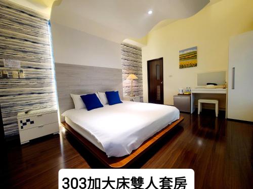 a bedroom with a large white bed with blue pillows at Beautiful Homestay in Suao