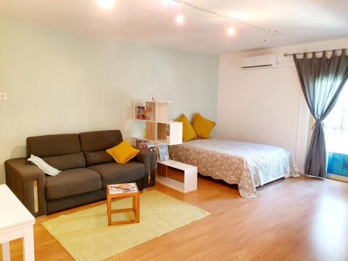 uma sala de estar com um sofá e uma cama em Center of Lisbon - University City em Lisboa