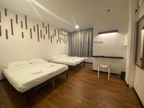 um quarto com duas camas e uma secretária em Kuching Hotel em Kuching