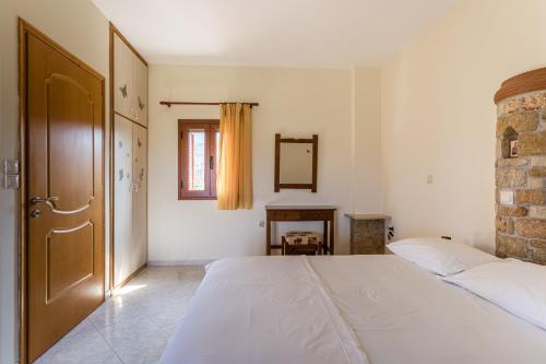 a bedroom with a large white bed and a window at Chioureas apartments in Levktron