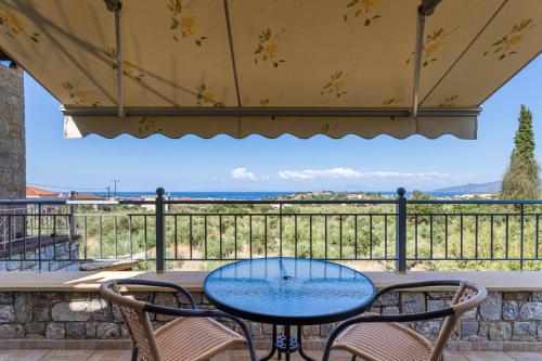 a table and chairs on a balcony with a view of the ocean at Chioureas apartments in Levktron