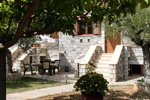a stone building with a table and chairs in a yard at Chioureas apartments in Levktron