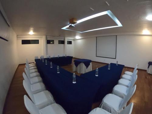 a conference room with a blue table and white chairs at Cantalagua Inn in Atlacomulco de Fabela