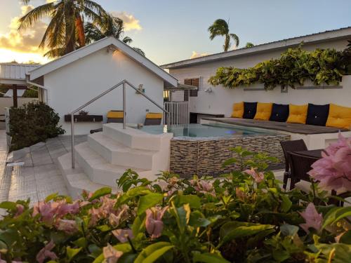 a house with a swimming pool and some flowers at Villa Boscardi in Belize City
