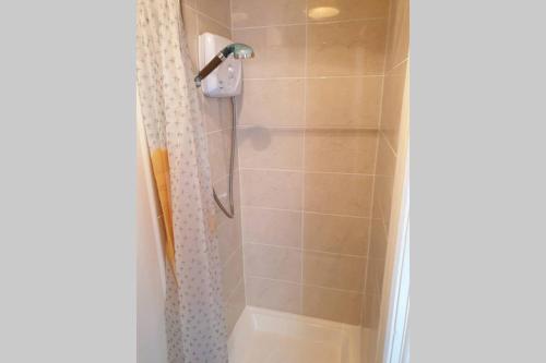 La salle de bains est pourvue d'une douche avec rideau de douche. dans l'établissement private-ensuite-room Limerick city stay, à Limerick