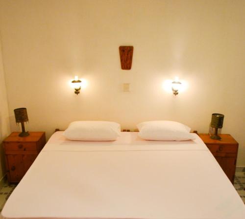 a bedroom with a white bed with two lights on the wall at Hotel Thai Lanka in Hikkaduwa