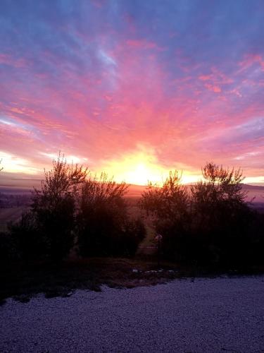 a sunset with the sun setting in the sky at Il Casale di Lavinia in Fabro