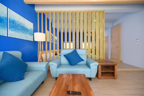 a living room with a blue couch and a table at 夏天民宿 in Magong