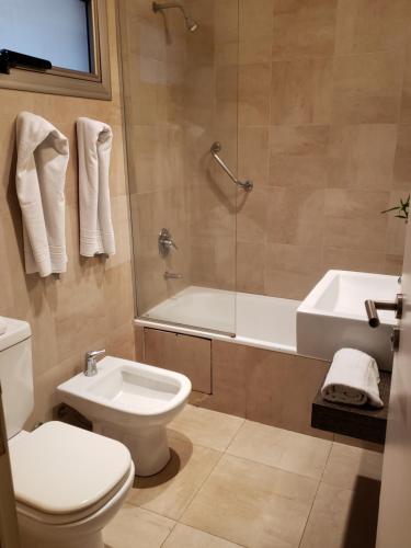 a bathroom with a toilet and a tub and a sink at Studio FR Palermo Hollywood in Buenos Aires