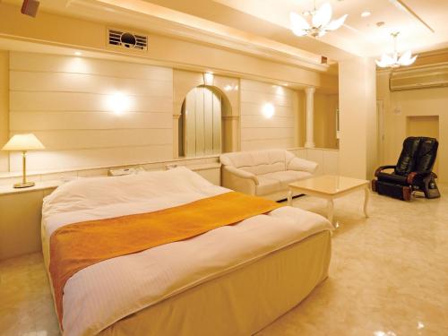 a bedroom with a bed and a chair and a table at Hotel Fine Garden Juso in Osaka