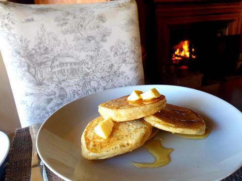 a plate of pancakes with butter and syrup on it at Waterford Manor in Rosetta