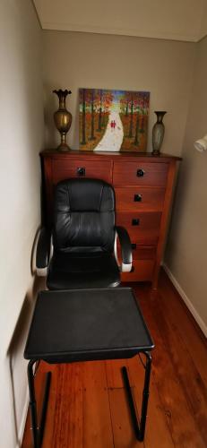a leather chair sitting in front of a dresser at Regent Residential Villa in Whangarei