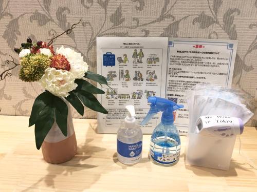 a table with a vase of flowers and a bottle of water at My Home in Tokyo in Tokyo