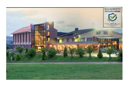 a large building in front of a grass field at Hotel Royal in Llanera