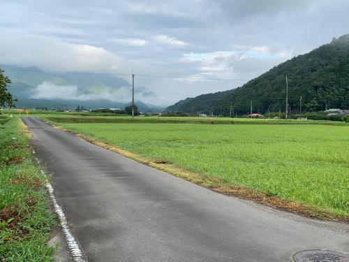 an empty road next to a field of grass at 民泊はのこの庭 in Kokuryō