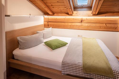 een bed in een kleine kamer met houten wanden bij Ferienwohnung "Hüs 18" in Fischen