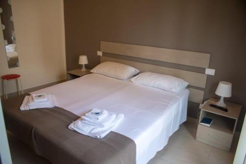 ein Schlafzimmer mit einem weißen Bett und Handtüchern darauf in der Unterkunft La Casita 24 in Palermo