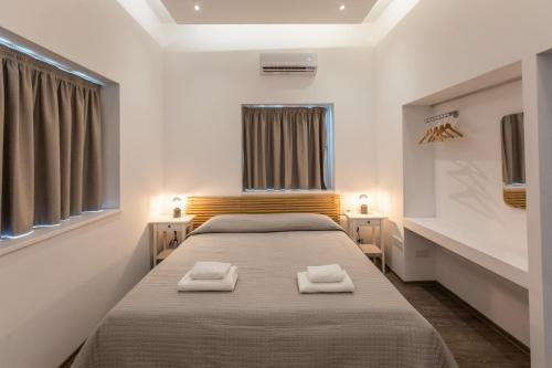 1 dormitorio con 1 cama con 2 toallas en Rooms - Unique staying in Paphos Centre en Pafos