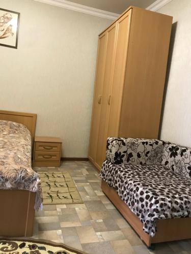 キスロヴォツクにあるApartment Lermontovaのベッドルーム1室(ベッド1台、ソファ、キャビネット付)