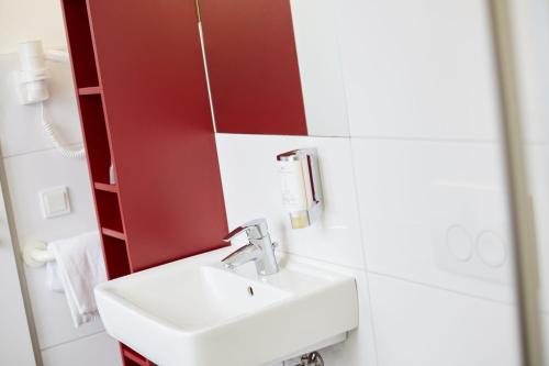 a bathroom with a sink and a mirror at Townhouse Düsseldorf in Düsseldorf