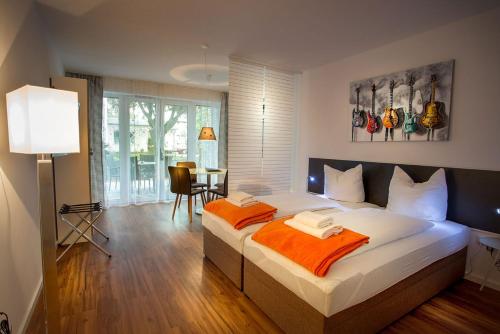 ein Schlafzimmer mit einem großen Bett mit einer orangefarbenen Decke in der Unterkunft H&H Apartment im Greifswald Eldena Nr19-Jonas mit Terrasse in Greifswald
