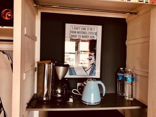 a shelf in a kitchen with a coffee maker at Pop Art Pad heart of Old Town with parking! in Hastings