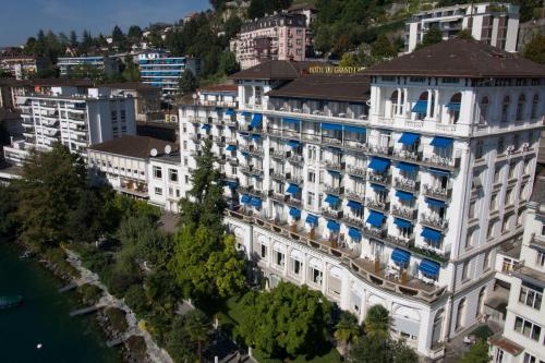 an aerial view of a large white building with blue balconies at Hôtel du Grand Lac Excelsior in Montreux