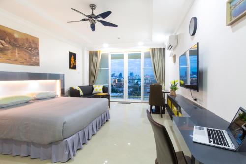 een slaapkamer met een bed en een bureau met een laptop bij Beautiful Apartment A6 Central Pattaya in Pattaya