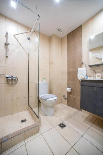 a bathroom with a shower and a toilet and a sink at Palotel Gouvia Hotel in Gouvia
