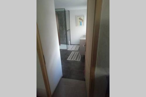 um corredor com uma porta que leva a uma casa de banho em petite maison de ville toute équipée em Château-Renard
