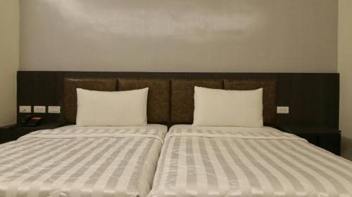 two beds sitting next to each other in a room at 萬酈精品旅館 in Kaohsiung