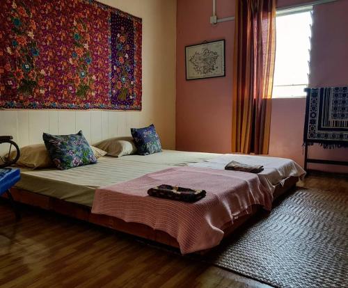 um quarto com uma cama com dois sapatos em Kunyit 7 Lodge em Bandar Seri Begawan