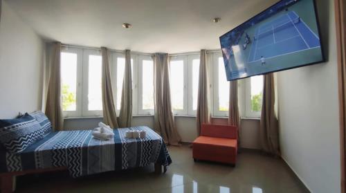 a bedroom with a bed and a flat screen tv at Guest House "Villa Klara Eilat" Heated pool and sauna all year round in Eilat