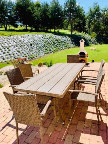 a wooden table and chairs on a patio at Vendvidéki Pihenőházak in Felsőszölnök