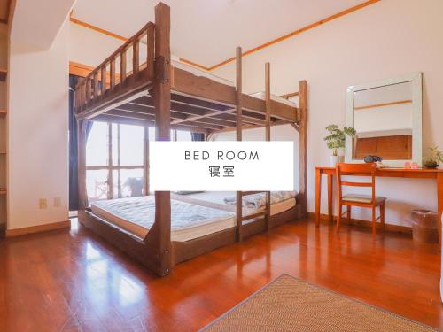 a room with two bunk beds and a desk at ALL FRIENDS Guest House in Nago