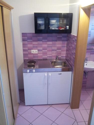 a small kitchen with a sink and a microwave at Apartments Angie in Biograd na Moru