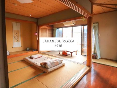 a japanese room with a bed in the middle of a room at ALL FRIENDS Guest House in Nago