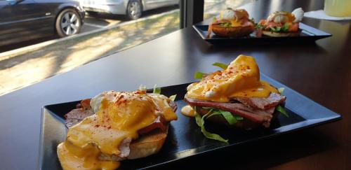 een sandwich met kaas en vlees op een bord op een toonbank bij Corso Apartments B&B in Focşani