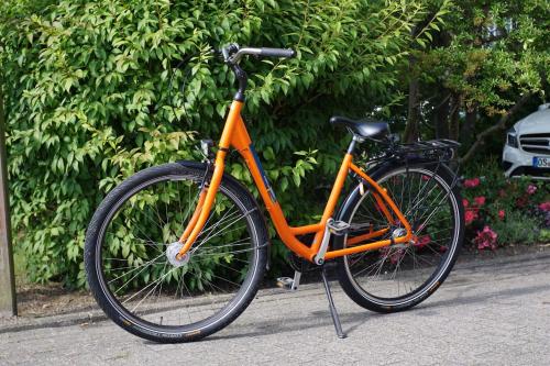 an orange bike is parked on a sidewalk at Ferienwohnung Schiffsblick Horumersiel in Wangerland