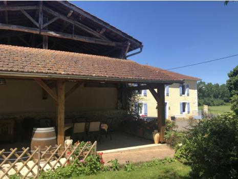 ein Haus mit einem Pavillon mit einem Tisch und Stühlen in der Unterkunft Chez Nicole et Michel in Monlezun